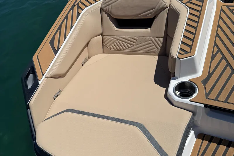 Slide: The Image of 2025 MasterCraft XStar 23 boat interior with tan upholstery and cup holder. - 16