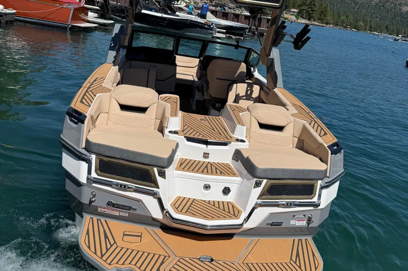 Slide: The Image of 2025 MasterCraft XStar 23 boat with luxurious seating on a serene lake. - 4