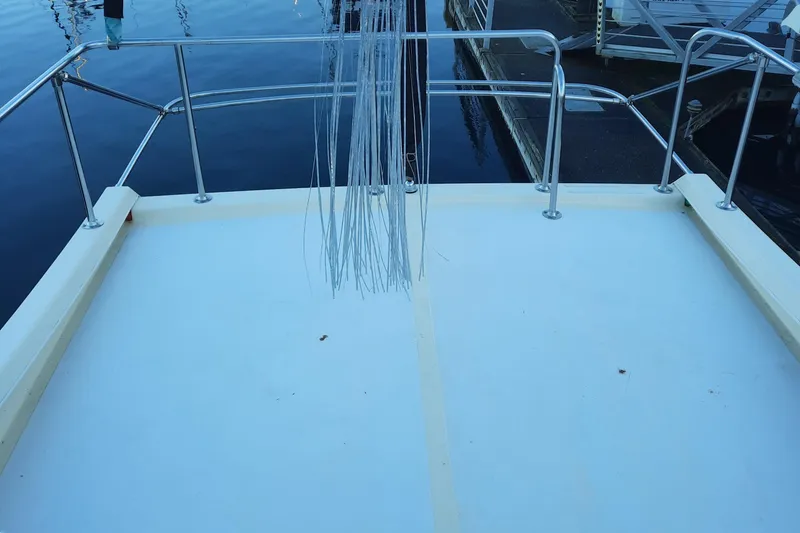 Slide: The Image of 2004 Camano Troll boat deck with railing, docked at marina. - 10