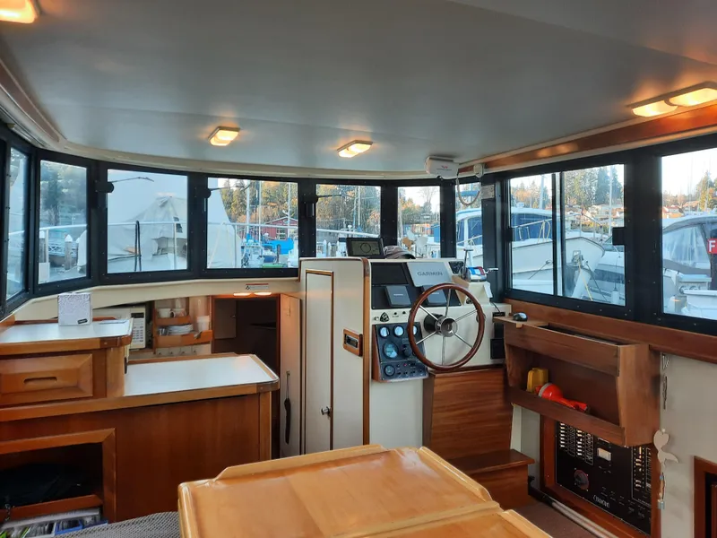 Slide: The Image of Interior of 2004 Camano Troll boat with helm, windows, and wooden cabinetry. - 11