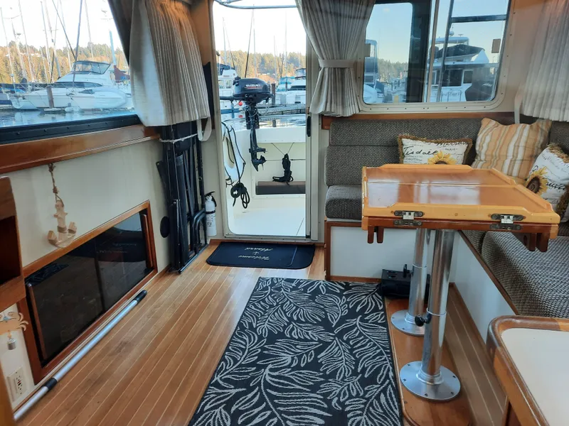 Slide: The Image of Interior of a 2004 Camano Troll boat with wood flooring and cozy seating area. - 13