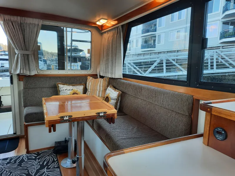 Slide: The Image of Interior of 2004 Camano Troll boat with cozy seating and wooden table. - 14