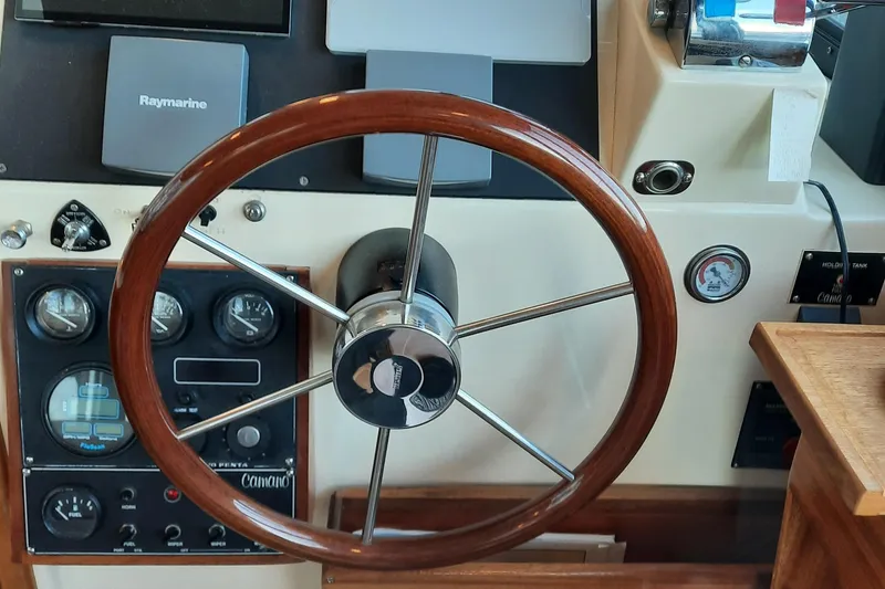 Slide: The Image of 2004 Camano Troll boat helm with wooden steering wheel and control panel. - 16