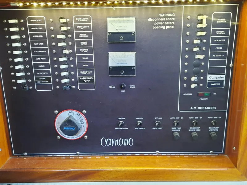 Slide: The Image of Electrical panel of a 2004 Camano Troll boat with various switches and meters. - 19