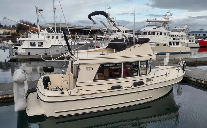 Slide: The Image of 2004 Camano Troll boat docked in marina, surrounded by other vessels under cloudy skies. - 2