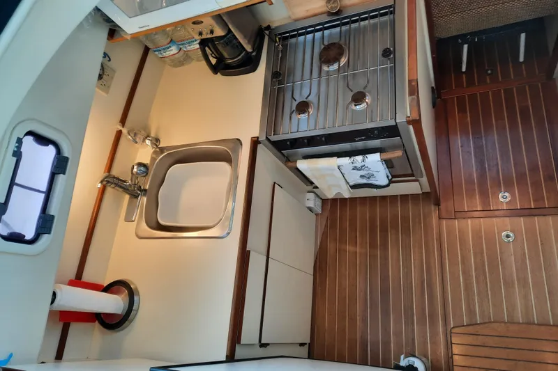 Slide: The Image of 2004 Camano Troll boat kitchen with sink, stove, and wooden flooring. - 20