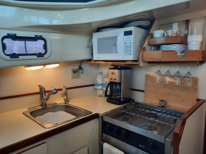 Slide: The Image of Compact kitchen in 2004 Camano Troll boat with sink, stove, microwave, and coffee maker. - 22