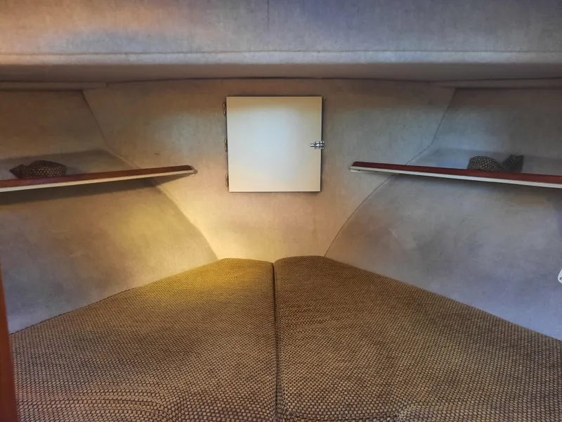Slide: The Image of 2004 Camano Troll boat interior with cozy sleeping area and storage shelves. - 26