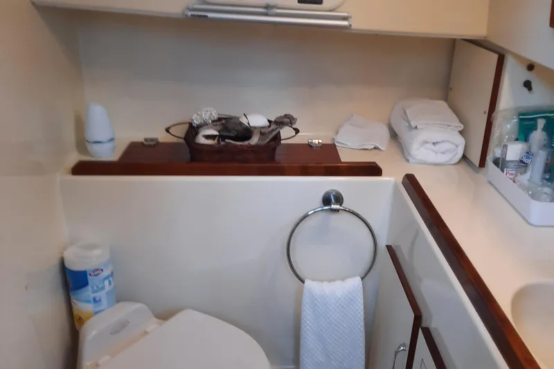 Slide: The Image of 2004 Camano Troll bathroom with toilet, towel, and toiletries neatly arranged. - 27