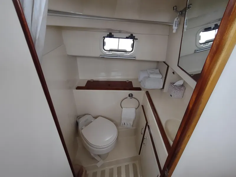Slide: The Image of 2004 Camano Troll boat bathroom with toilet, sink, mirror, and window. - 30