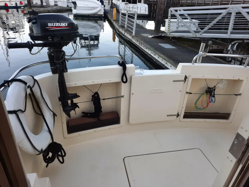 Slide: The Image of 2004 Camano Troll boat stern with Suzuki outboard motor, docked at marina. - 6