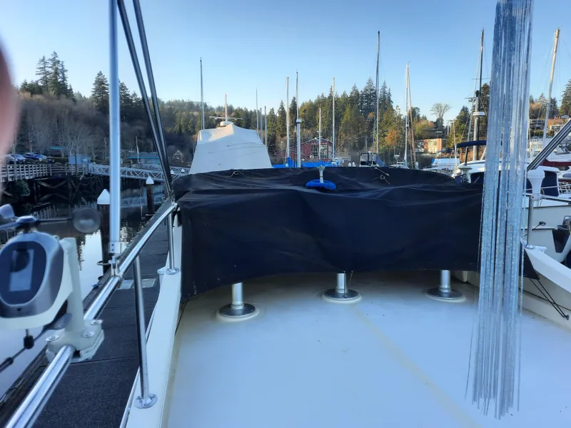 Slide: The Image of 2004 Camano Troll boat docked at marina with covered deck and scenic background. - 8