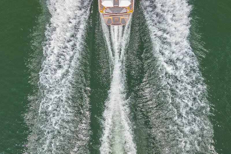 Slide: The Image of Aerial view of 2022 Centurion Ri245 boat creating waves on green water. - 13