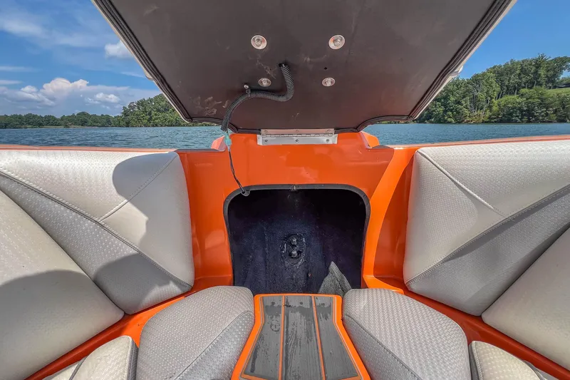 Slide: The Image of 2022 Centurion Ri245 boat interior with orange accents, open hatch, and lake view. - 17