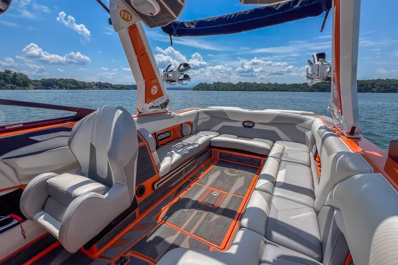 Slide: The Image of Luxurious 2022 Centurion Ri245 boat interior with plush seating on a sunny lake. - 18
