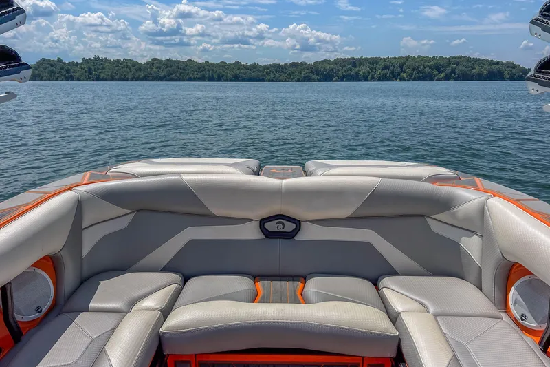 Slide: The Image of 2022 Centurion Ri245 boat interior with luxurious seating on a serene lake. - 21