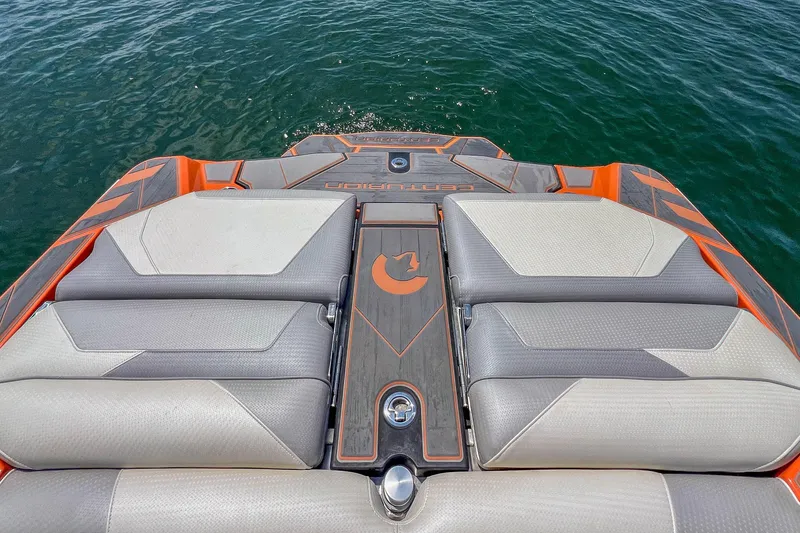 Slide: The Image of 2022 Centurion Ri245 boat with orange and gray seating, on calm water. - 22