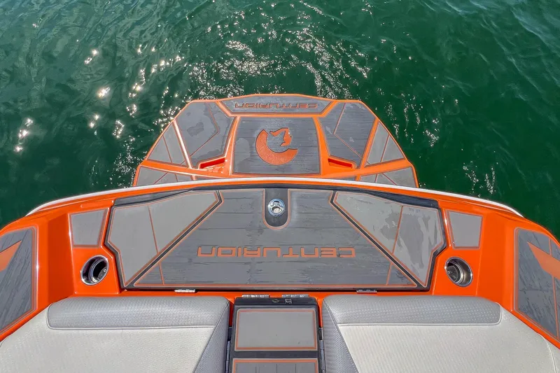 Slide: The Image of 2022 Centurion Ri245 boat deck with vibrant orange and gray design on water. - 23