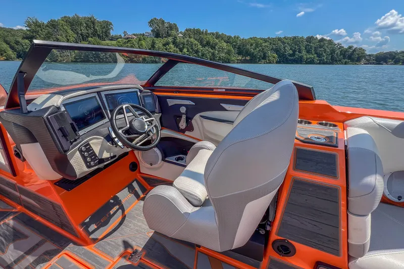 Slide: The Image of 2022 Centurion Ri245 boat interior with modern dashboard and lake view. - 24