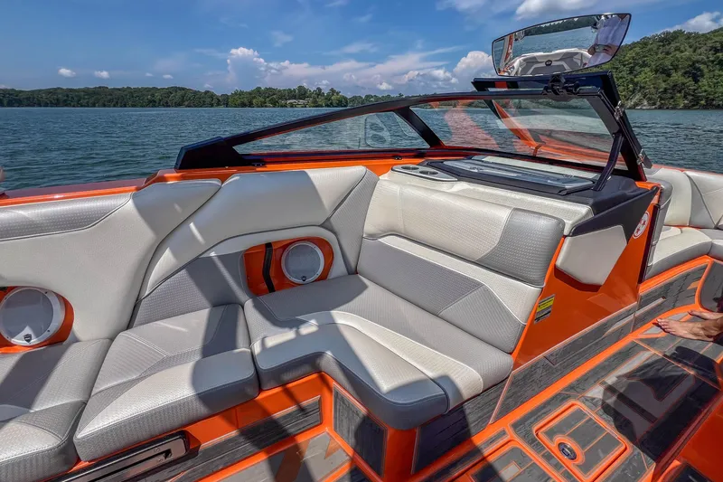 Slide: The Image of 2022 Centurion Ri245 boat interior with orange accents on a sunny day. - 25