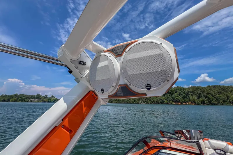 Slide: The Image of 2022 Centurion Ri245 boat with mounted speakers on a sunny lake. - 28