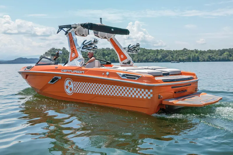 Slide: The Image of 2022 Centurion Ri245 boat in vibrant orange on a serene lake. - 3