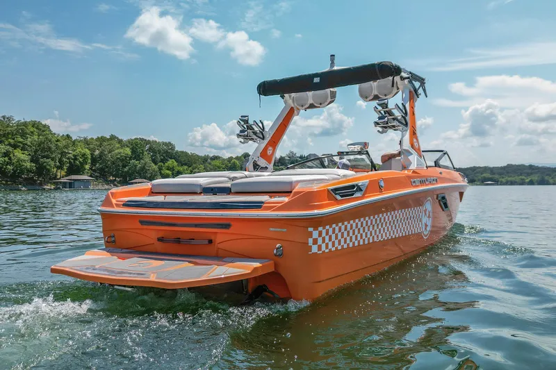 Slide: The Image of 2022 Centurion Ri245 boat in vibrant orange on a serene lake. - 5