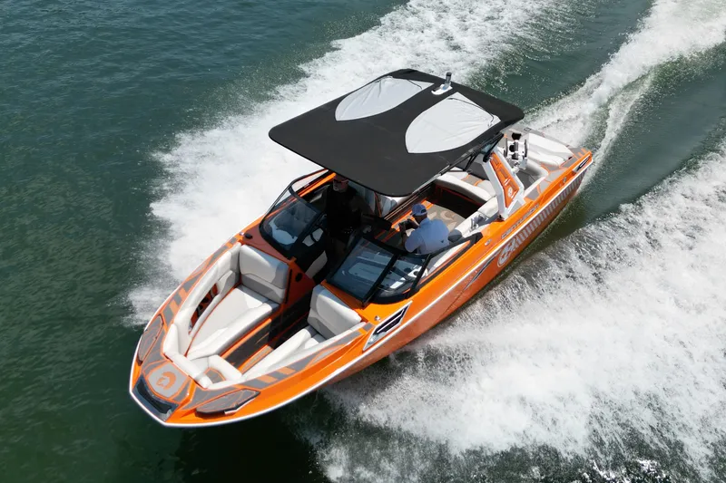 Slide: The Image of 2022 Centurion Ri245 boat cruising on water, featuring vibrant orange design and spacious seating. - 6