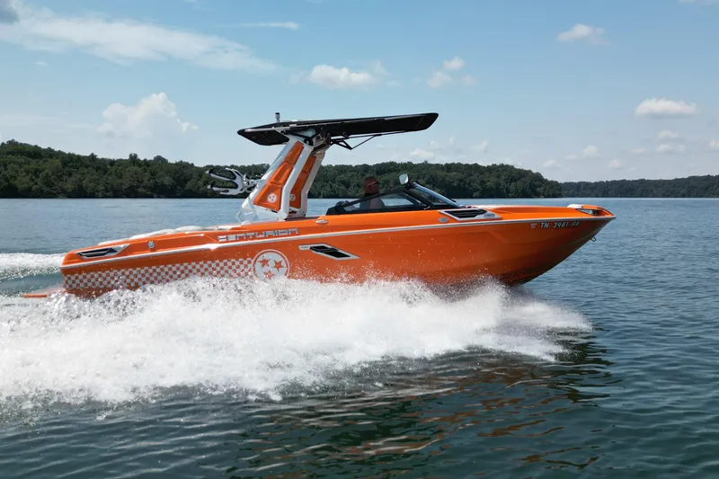 Slide: The Image of 2022 Centurion Ri245 boat cruising on a lake with lush green shoreline. - 8