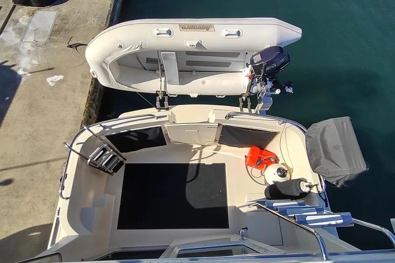 Slide: The Image of 2000 Camano Troll boat with inflatable dinghy and outboard motor at dockside. - 11