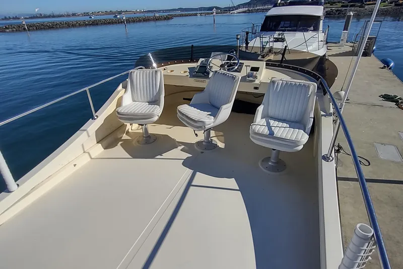 Slide: The Image of 2000 Camano Troll boat with three white seats on deck, docked by calm waters. - 12