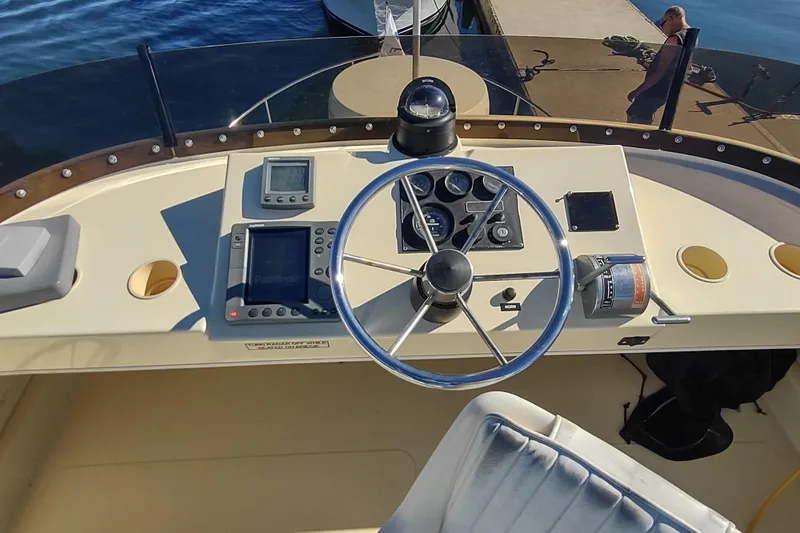 Slide: The Image of 2000 Camano Troll boat dashboard with steering wheel, navigation instruments, and throttle controls. - 14