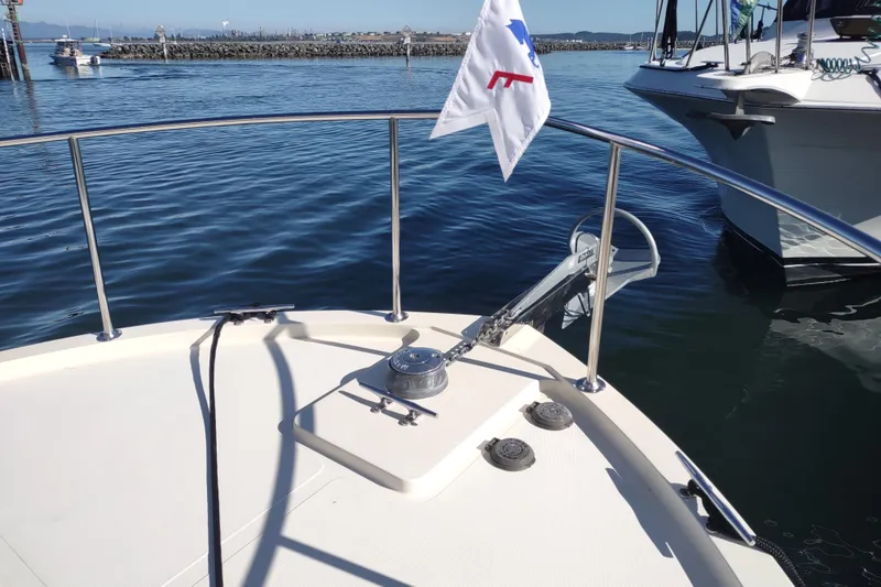 Slide: The Image of Bow of a 2000 Camano Troll boat with anchor and flag in a marina. - 15