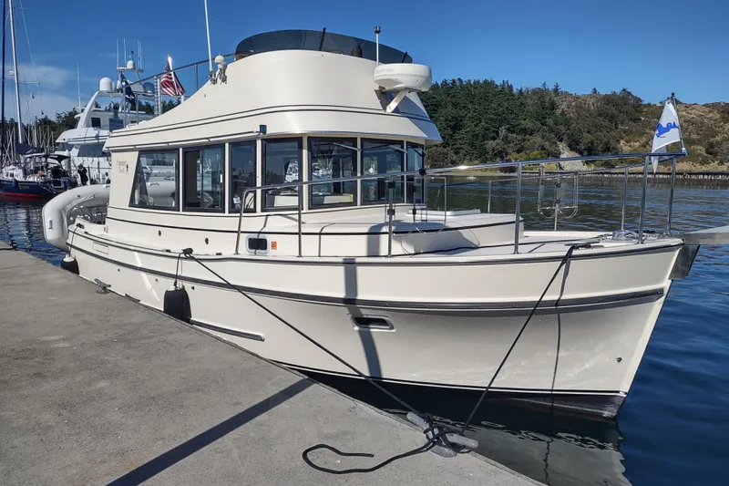 Slide: The Image of 2000 Camano Troll boat docked at a marina, clear sky, calm water. - 2