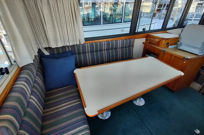 Slide: The Image of Interior of 2000 Camano Troll boat with striped seating and dining table. - 22