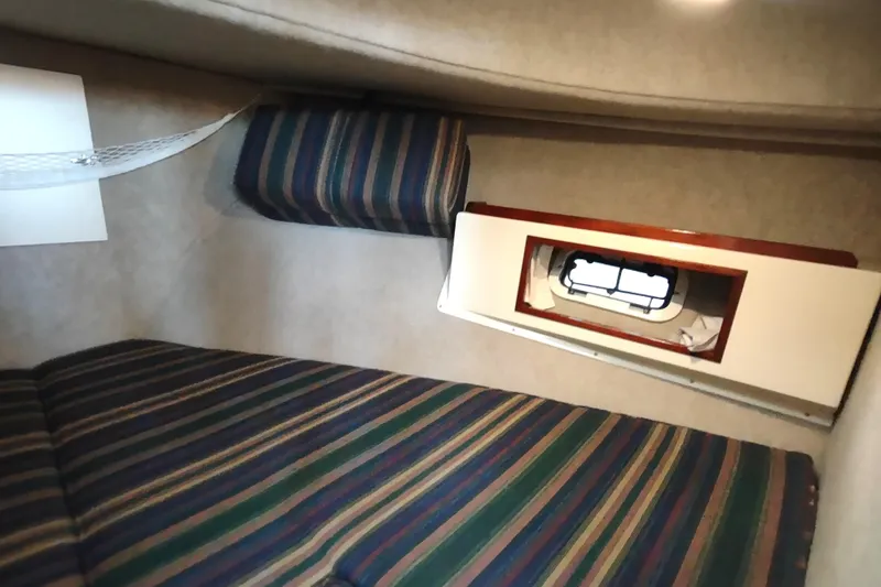 Slide: The Image of Interior cabin of 2000 Camano Troll boat with striped upholstery and small window. - 41