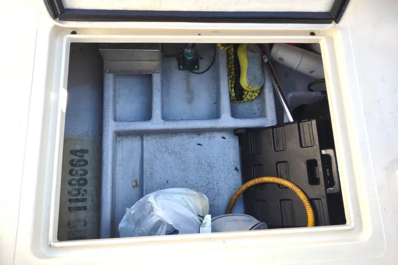 Slide: The Image of Storage compartment of a 2000 Camano Troll boat with various equipment and supplies. - 46