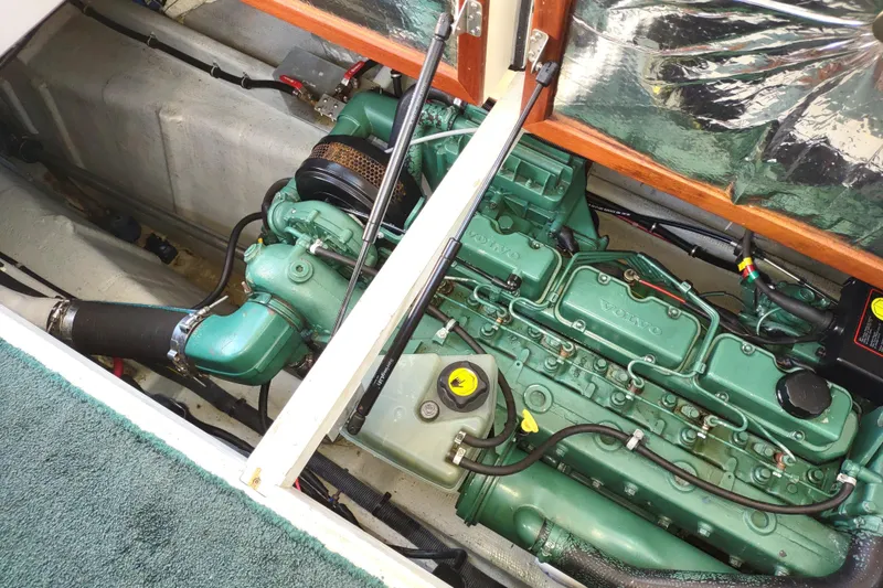Slide: The Image of Engine compartment of a 2000 Camano Troll boat, featuring a green Volvo engine. - 48