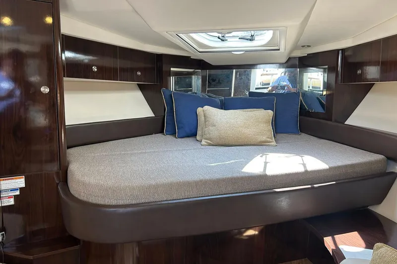 Slide: The Image of 2019 Sea Ray Sundancer 350 Coupe cabin with plush bedding and elegant wood finishes. - 11