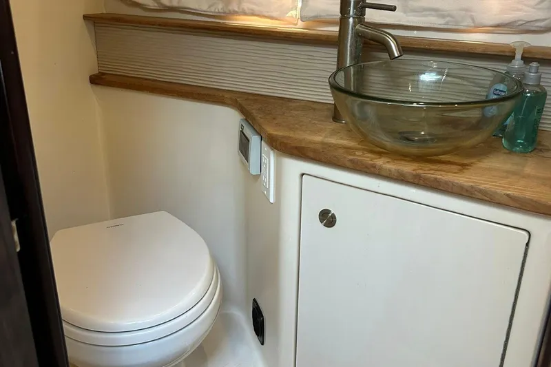 Slide: The Image of 2019 Sea Ray Sundancer 350 Coupe bathroom with glass sink and modern fixtures. - 13