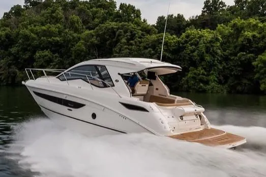 Slide: The Image of Manufacturer Provided Image: 2019 Sea Ray Sundancer 350 Coupe cruising on a lake with lush green trees in the background. - 17