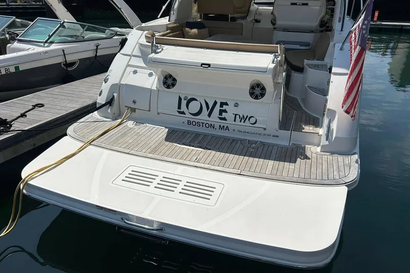 Slide: The Image of 2019 Sea Ray Sundancer 350 Coupe docked, rear view with American flag and Boston, MA label. - 3