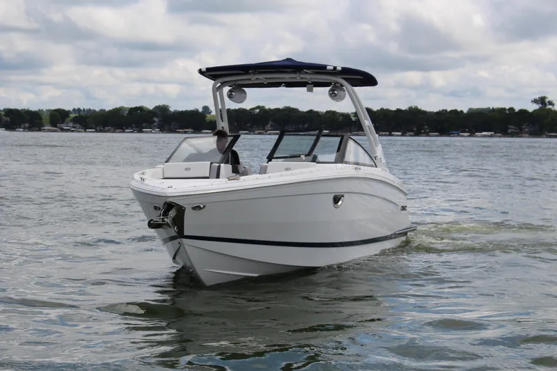 The Image of 2024 Cobalt R8 Outboard boat cruising on a lake under cloudy skies. - 1