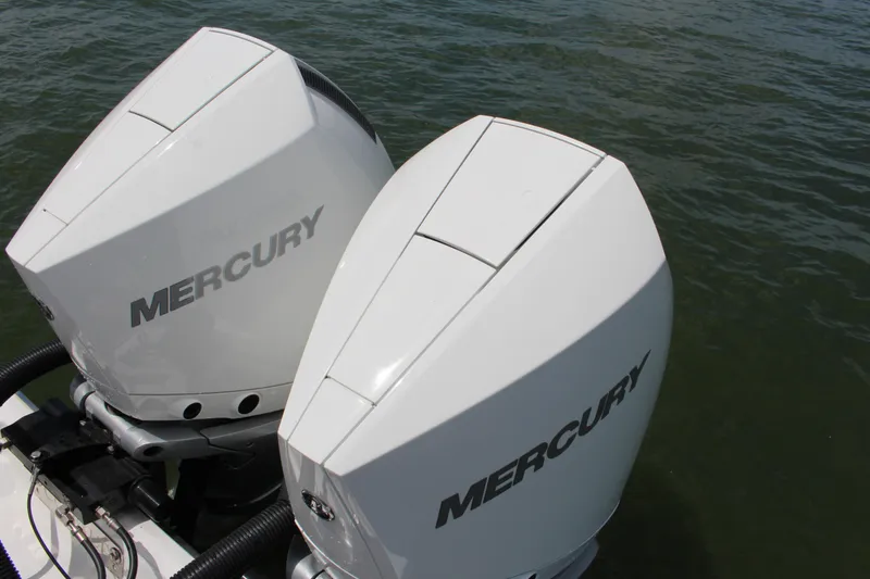 Slide: The Image of Twin Mercury outboard engines on a 2024 Cobalt R8 boat, floating on water. - 12