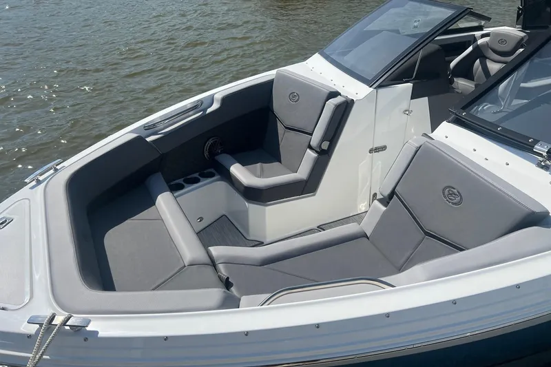 Slide: The Image of 2024 Cobalt R6 Surf boat with sleek gray seating on calm water. - 3