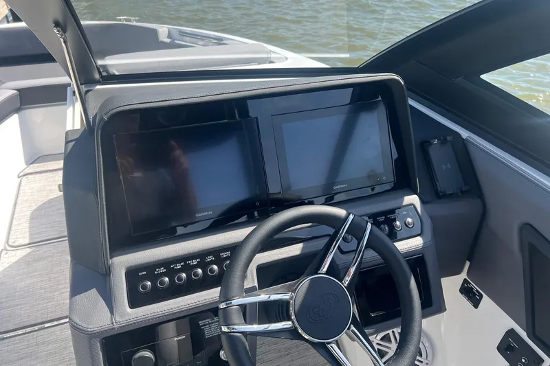 Slide: The Image of 2024 Cobalt R6 Surf boat dashboard with dual Garmin displays and sleek steering wheel. - 5