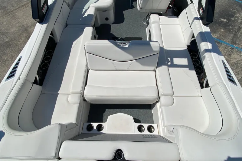 Slide: The Image of 2022 MasterCraft XT25 boat interior with white seating and cup holders. - 11