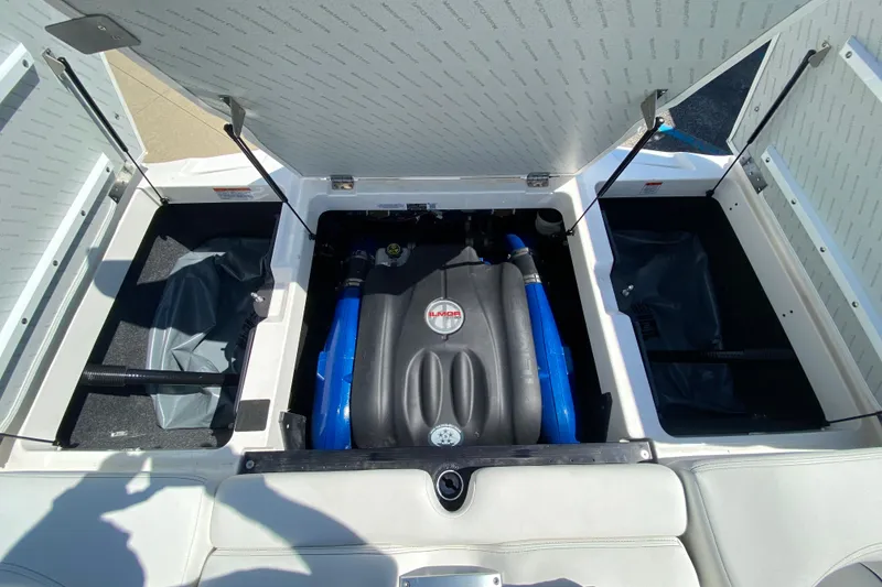 Slide: The Image of 2022 MasterCraft XT25 engine compartment with Ilmor engine, open storage hatches, and blue hoses. - 12