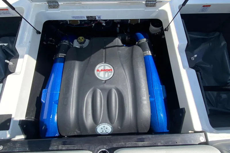 Slide: The Image of 2022 MasterCraft XT25 engine compartment with Ilmor engine, featuring blue hoses. - 13