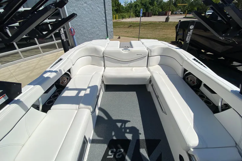 Slide: The Image of 2022 MasterCraft XT25 boat interior with white seating and cup holders. - 15